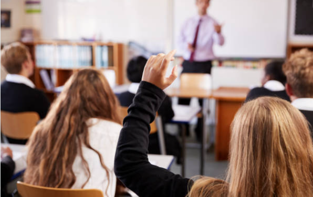 Salón de clases con la mano levantada