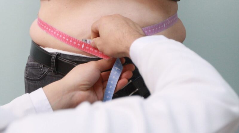 doctor midiendo abdomen de paciente mujer